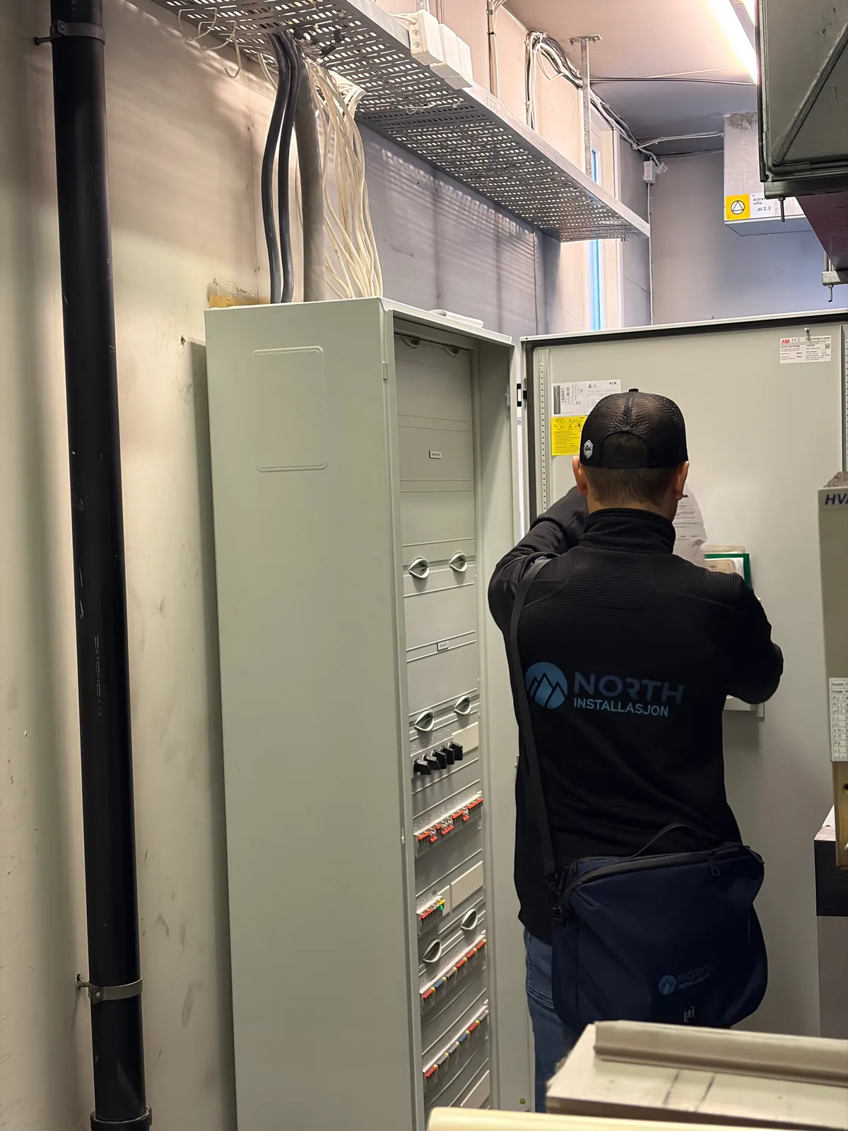Elektriker fra North Installasjon jobber ved et hovedfordelingsskap i et teknisk rom